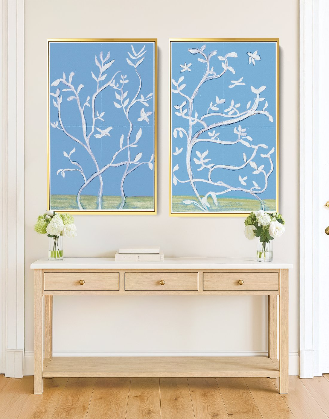 Blue and white botanical prints in gold frames above a console table